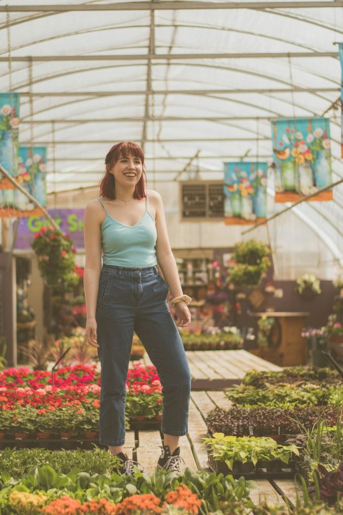 woman-standing-near-flower-pots-inside-greenhouse-adp24ah9zi